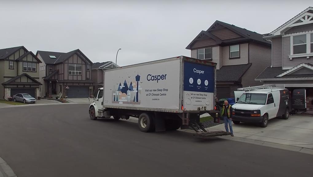 Truckside Advertisement photo of a delivery truck in a residential neighborhood making it look like Casper Mattress are being delivered