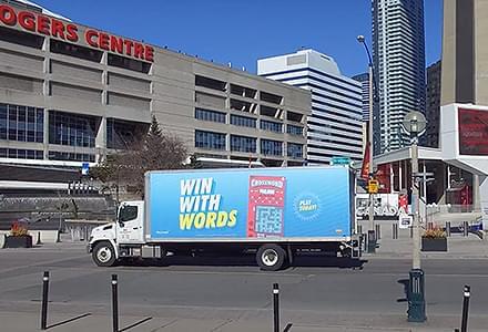 Truck Advertisement for OLG crossword ad parked outside Ripley's Aquarium in Toronto. The copy says ”Win with words”