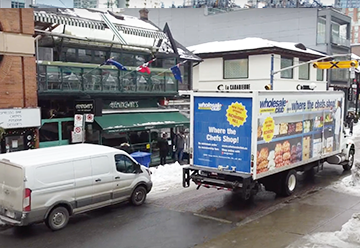 Mobile billboard advertisement for Wholesale Club on side of truck