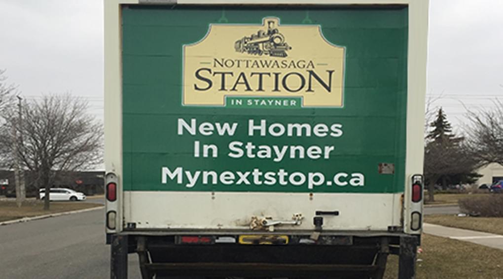 Truckside Advertisement photo of MacPherson Home Builders showing case a new development in Stayner Ontario