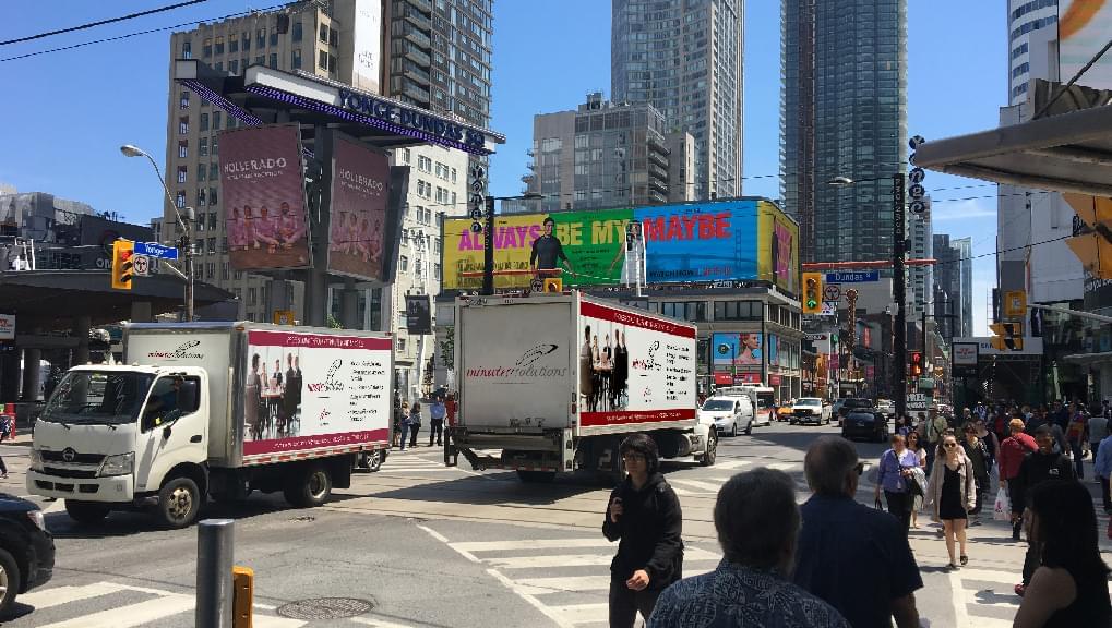 Two Truckside Advertisements for Minute Solutions at Dundas Square in Toronto