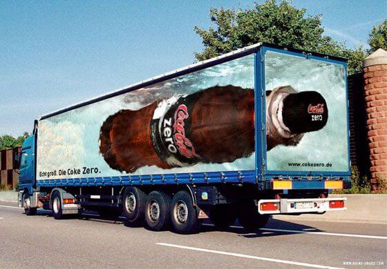 truck's trailer ad creating a =n illusion of a giant coca cola bottle