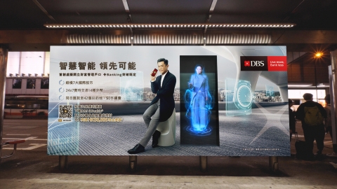 An image of a DOOH ad for DBS with holographic actors on it.