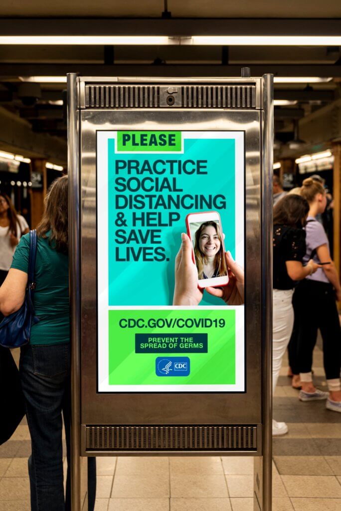 An image of an OOH ad by the CDC in the subway telling people to practice social distancing.