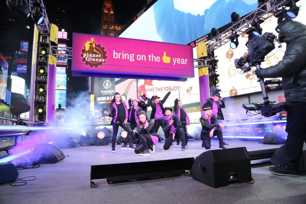 Performances in Times Square with a Planet Fitness billboards in Times Square.