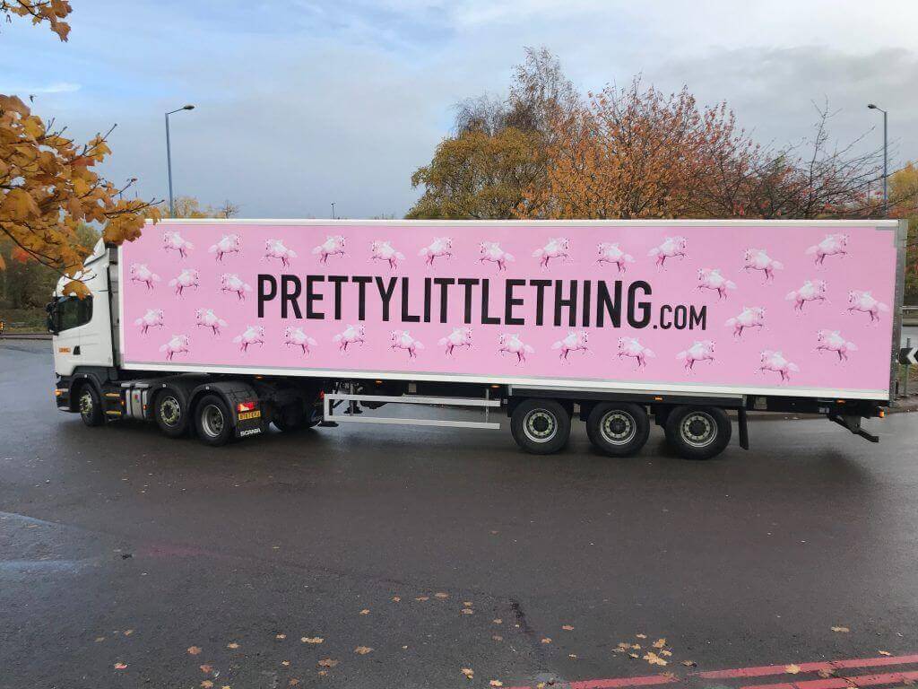 Image of an 18 wheeler truck displaying little pink flying horses. This ad reads "Prettylittlething.com". 