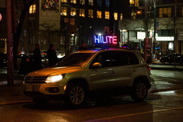 An image of a car with a fluorescent Hilite sign on top of it.