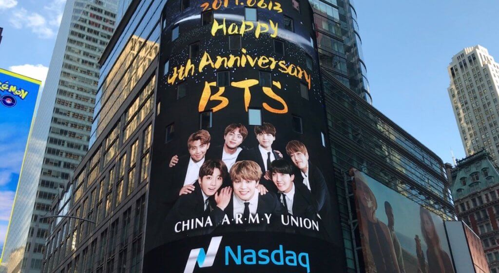 An image of a large digital OOH billboard celebrating the band BTS.