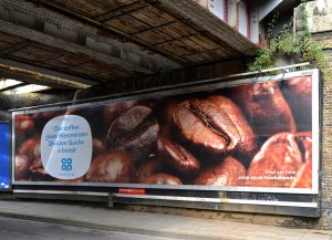 An image of a billboard on a wall for Co-op with coffee beans all over it.