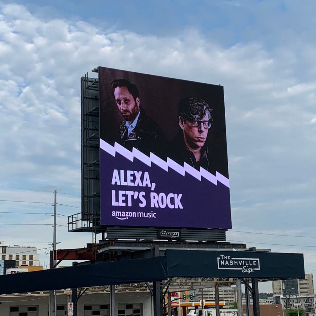An image of a giant billboard ad for Amazon Music. The billboard displays two artists.