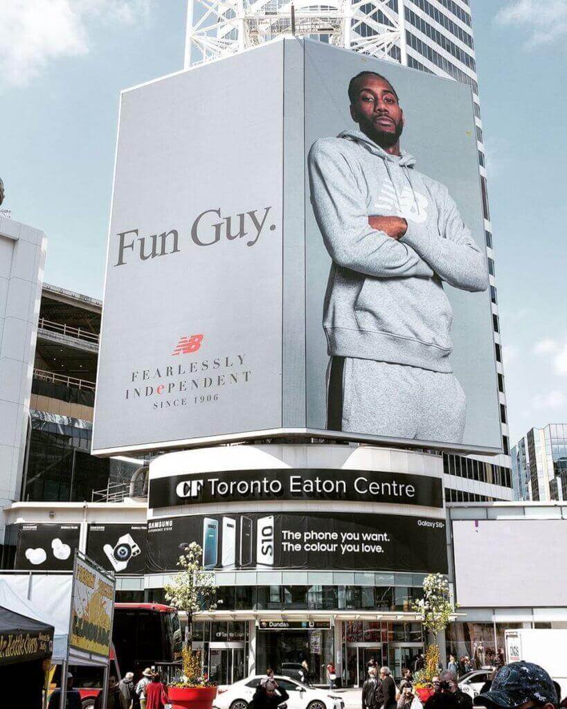 An image of a large billboard of Kawhi Leanord that says "Fun Guy.". It is an advertisement for New Balance.