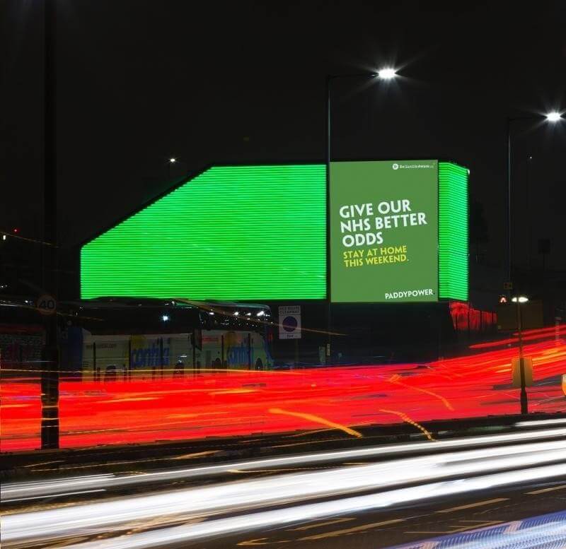 An image of a large DOOH billboard made by PaddyPower. It's bright green.