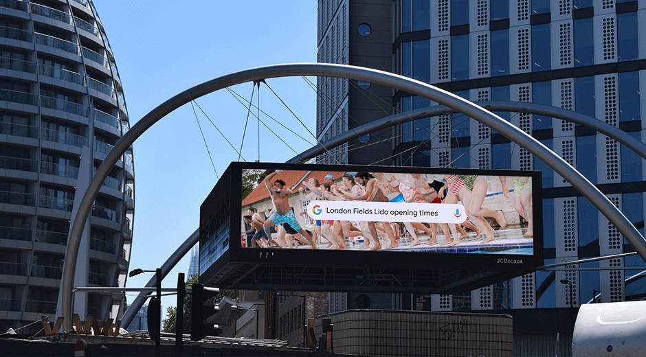 An image of a DOOH billboard for Google with a bunch of kids on it jumping into a pool with a google search on it.