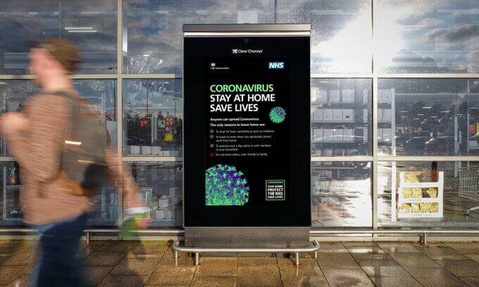 An image of a billboard that talks about the benefits of staying home and statistics about the COVID-19 virus.