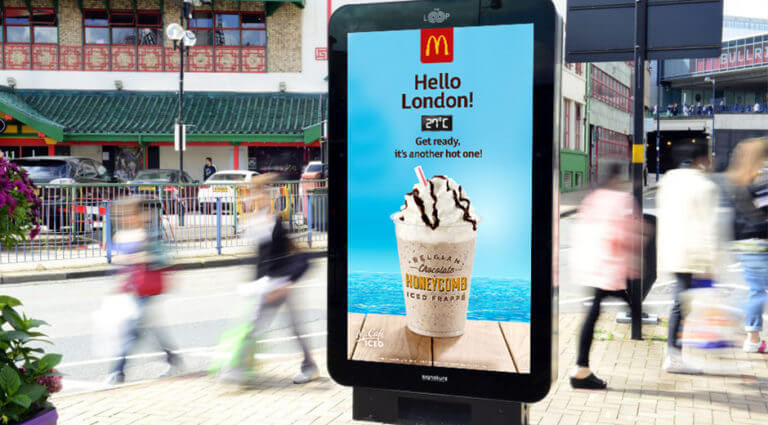 An image of a DOOH billboard ad for McDonald's that's promoting a iced frappe and displays the current temperature.
