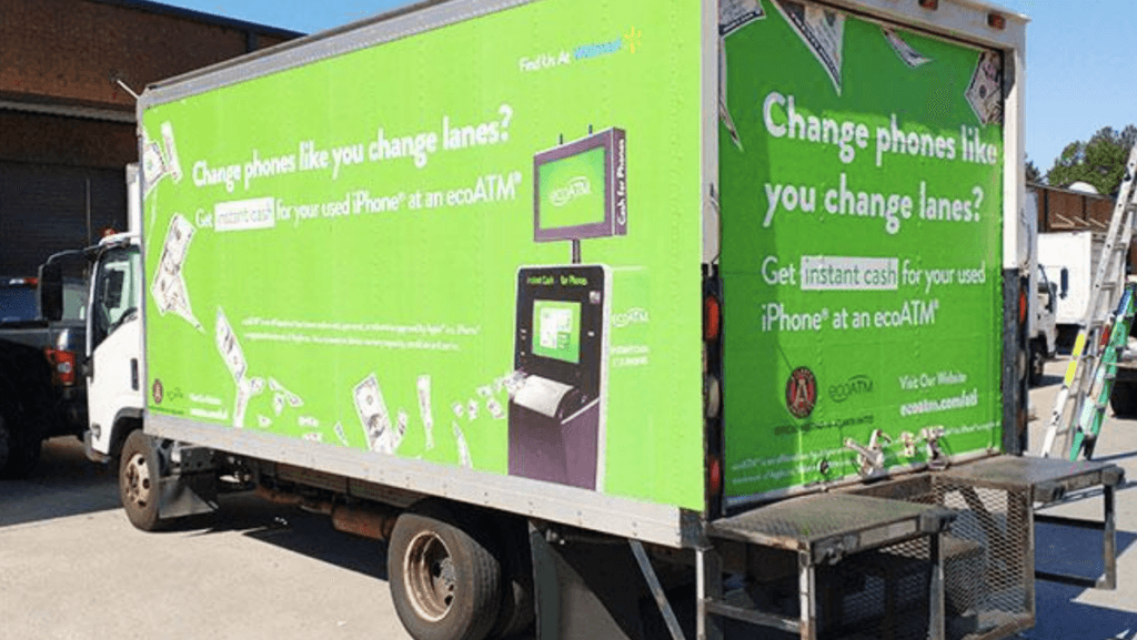 A truck with green colored mobile billboard ads of Walmart on all sides of the trucks. The ad says 'Change phones like you change lanes?'