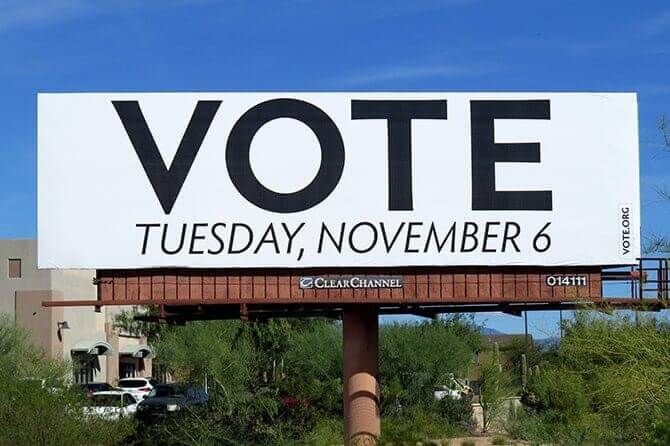An image of a billboard that reads, "vote" and the date, Tuesday, November 6. In black and white.