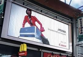 Trivision billboard depicting a woman in a red suit.