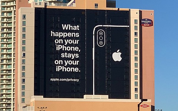 An image of an ad on the side of a building for Apple. Says, "What happens on your iPhone, stays on your iPhone."