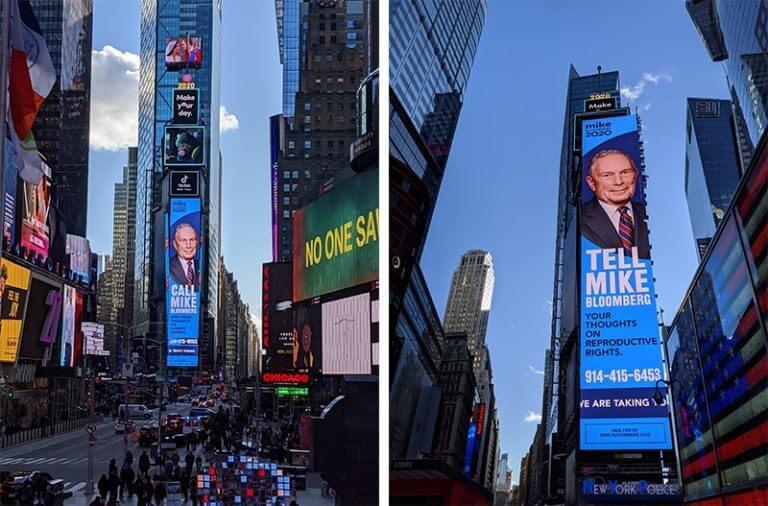 An image of a giant vertical billboard in the middle of Times Square. It has a picture of Mike Bloomberg on it that says, "tell Mike Bloomberg your thoughts on reproductive rights." and then has a number to call underneath.