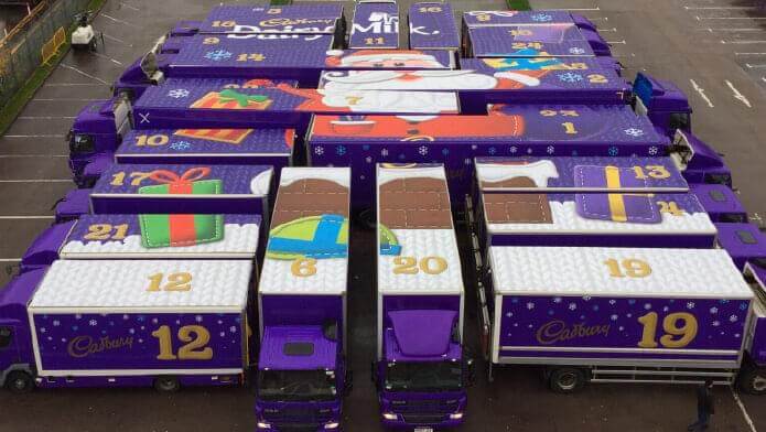 An image of an assortment of trucks with Cadbury chocolate advertising on them.
