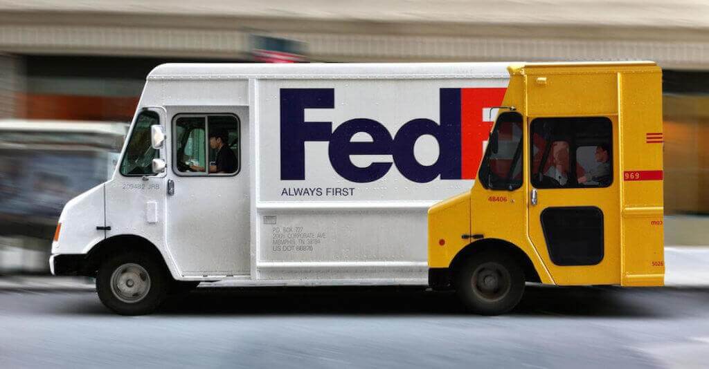 An image of a speeding FedEx truck with an ad on the side that has FedEx ahead of the truck with the text "always first" underneath the logo.