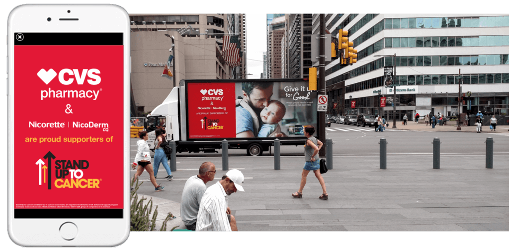 Photo showing a CVS pharmacy advertisement appearing on both a smartphone and a truckside billboard.