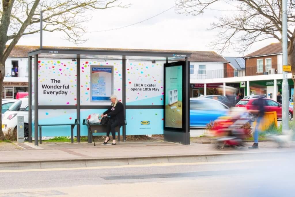 An image of a bus-stop ad for IKEA. Bus stop includes IKEA benches and a sliding billboard with IKEA furniture on it.