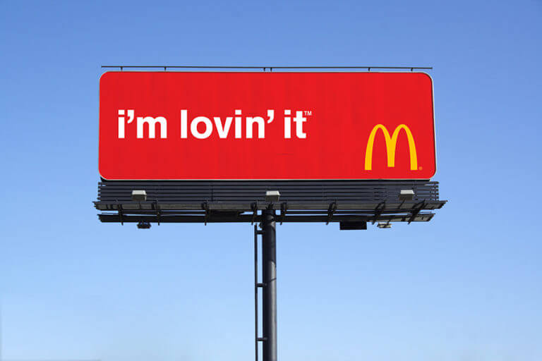 A McDonald's billboard ad with a red background and the logo in the corner, with the text "I'm lovin it".