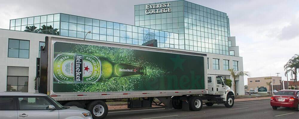 An image of a truck-side advertisement for Heineken. The bottle of Heineken is sideways on the truck with water spraying off of it.