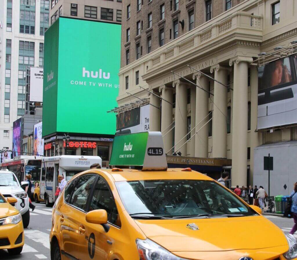Image of digital billboard advertising Hulu streaming service saying , "Hulu Come TV with us"