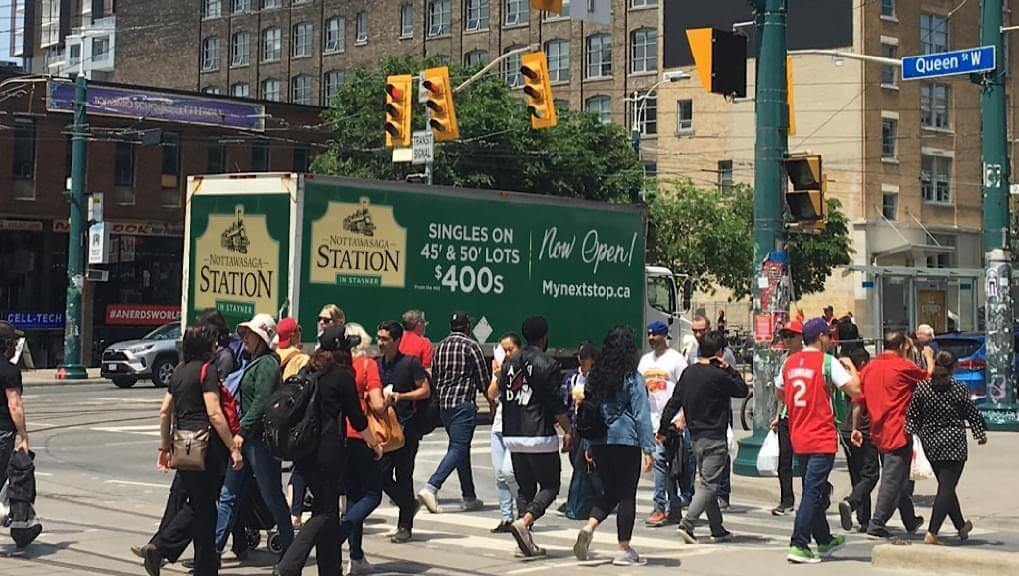 Picture of MacPherson Builders trackside mobile billboard ad on Queens Street West in Toronto, Ontario.