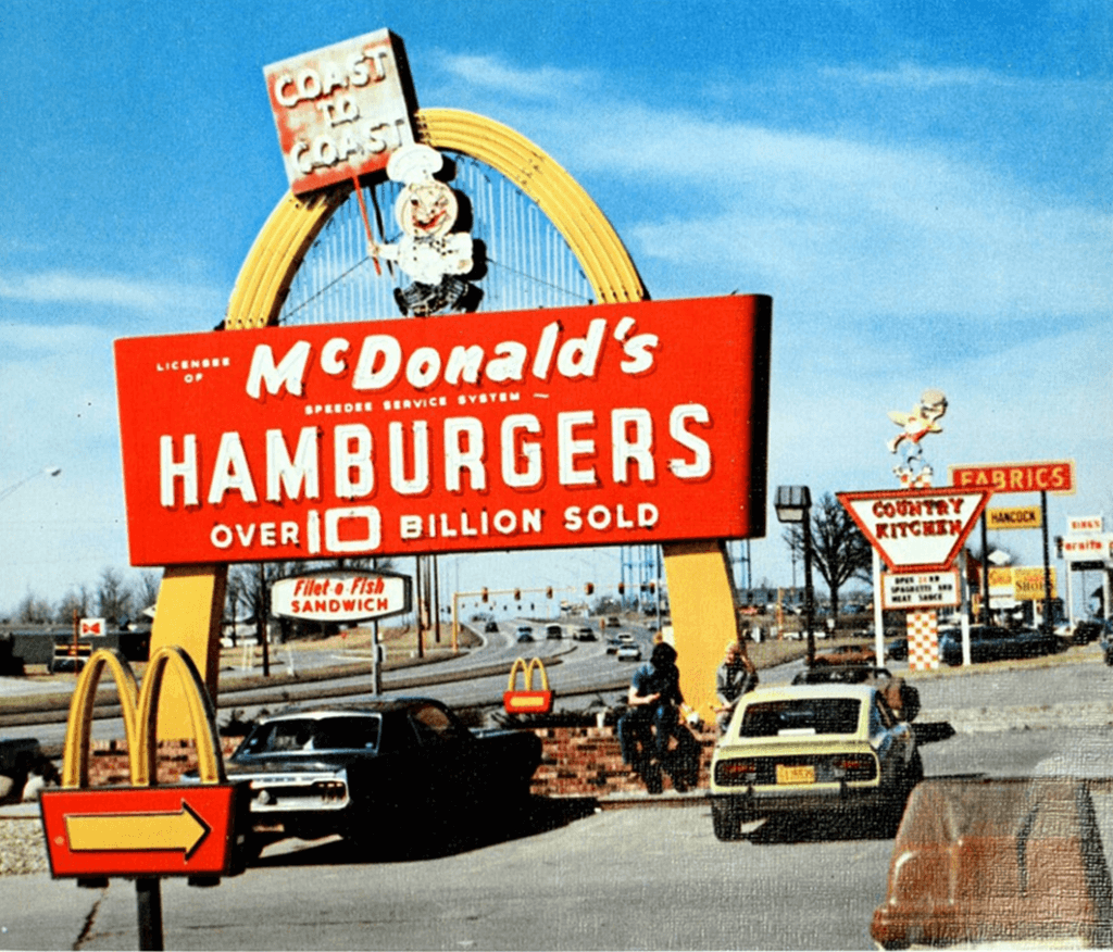 One of the first McDonald's opened, the golden arch with a red background and text "McDonald's Hamburgers over 10 billion sold".