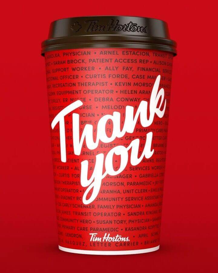 An image of a Tim Hortons coffee cup with the words "Thank You" written on it in bold white cursive letters. Also has the names of hundreds of essential workers on it in the background of the cup.