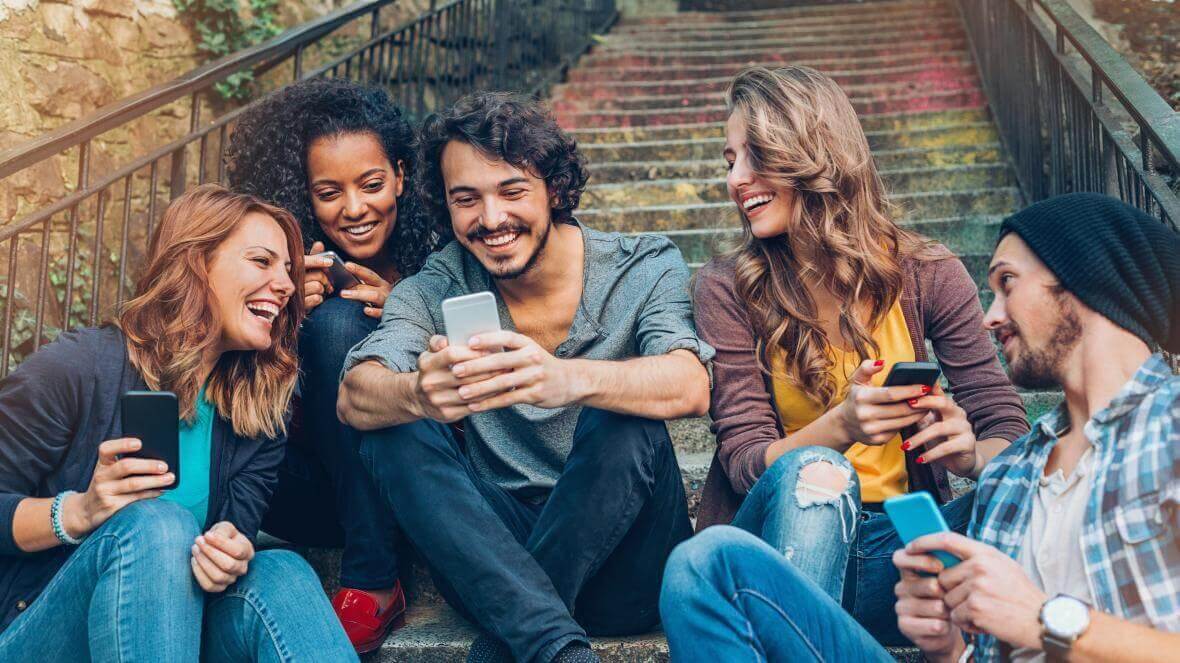 An image of young people on their phones together.