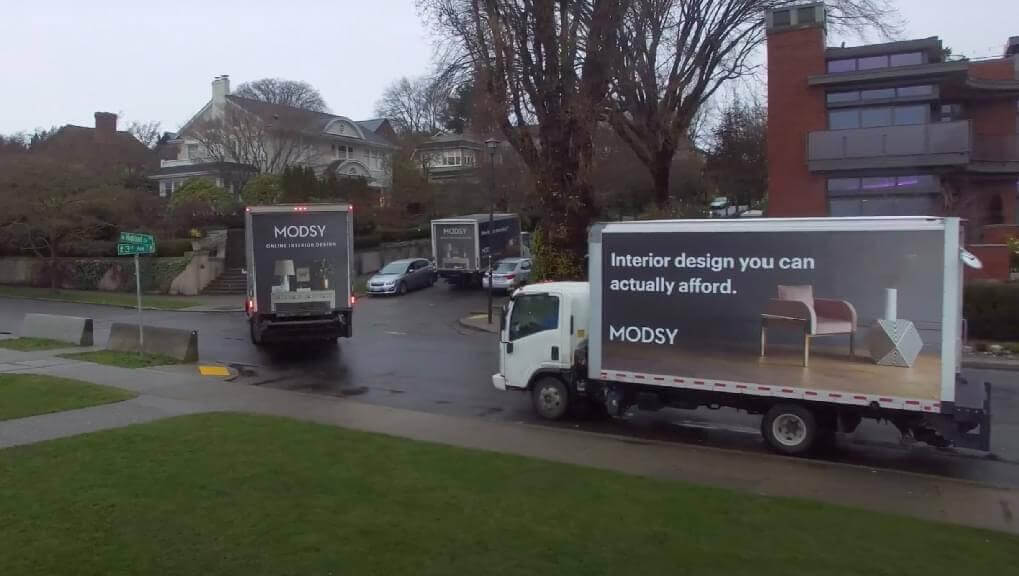 Movia mobile advertising trucks with Modsy billboards on them.