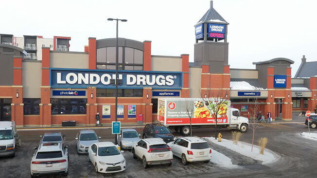 An image of a parking lot and focusing on a Shoppers Drug Mart and the subsequent truck-side ad for Shoppers.