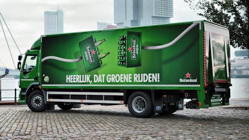 An image of a truck-side ad for Heineken that says, "Heerlijk, dat groene rijden!". The truck is green and has two cases of beer joining together as if to be plugged in.