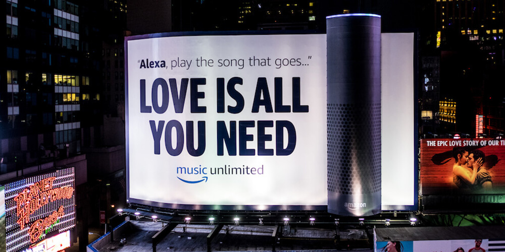 An image of a massive billboard in the middle of Times Square in NYC. The billboard is an ad for Amazon Music and includes a giant Amazon speaker.