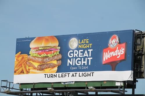 Wendy's billboard advertisement. Ad gives directions to local restaurant: "Turn left at light".